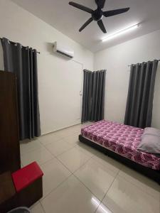 - une chambre avec un lit et un ventilateur de plafond dans l'établissement Bungalow Homestay Jasin, à Malacca
