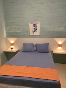 sypialnia z łóżkiem z 2 poduszkami i 2 światłami w obiekcie Ampla casa de 3 quartos com piscina w mieście Porto de Galinhas