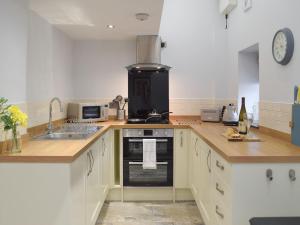 cocina con fregadero y fogones horno superior en Bluebell Cottage - Uk12988, en Monington