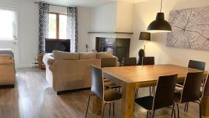 a living room with a table and a couch at Chalets Montmorency Mont-Sainte-Anne in Saint-Férréol-les-Neiges
