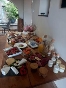 una mesa con un montón de comida. en LA TOUR des fées-spa, en Mittelbergheim