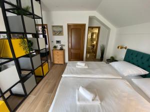 a bedroom with two beds and a book shelf at Holiday home Casa Rio in Vinkovci