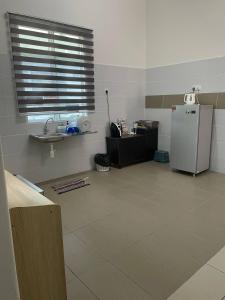 a kitchen with a refrigerator and a tile floor at BUNGALOW homestay JASIN PERDANA in Jasin