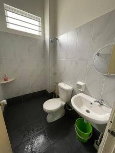 a bathroom with a white toilet and a sink at BUNGALOW homestay JASIN PERDANA in Jasin