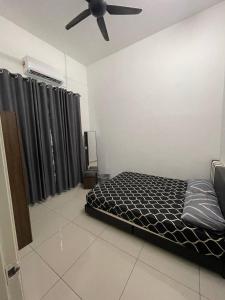 a bedroom with a bed and a ceiling fan at BUNGALOW homestay JASIN PERDANA in Jasin