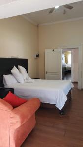 een slaapkamer met een groot bed en een bank bij 13 Maitland Road in Koning Willemstad