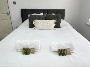 a white bed with green and white towels on it at Orchid House in Birmingham