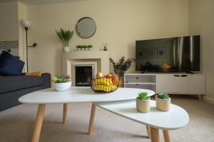 a living room with a coffee table and a tv at Luxury 2-bedroom 2-bathroom city centre apartment in Lichfield