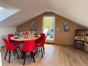 a dining room with a table and red chairs at *Wohnung SCHWARZWALD*Unikat in VS mit Terrasse in Villingen-Schwenningen