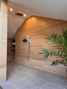 a shower in a bathroom with a wooden wall at *Wohnung SCHWARZWALD*Unikat in VS mit Terrasse in Villingen-Schwenningen