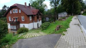 uma casa sentada ao lado de uma estrada em na Slowackiego em Szklarska Poręba
