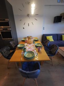 a dining room table with a clock on the wall at K&Scielna4013 in Świdnica