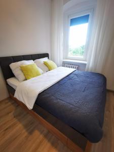 a bed with yellow pillows and a window in a bedroom at K&Scielna4013 in Świdnica