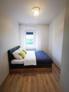 - une chambre avec un lit doté d'oreillers jaunes et d'une fenêtre dans l'établissement K&Scielna4013, à Świdnica