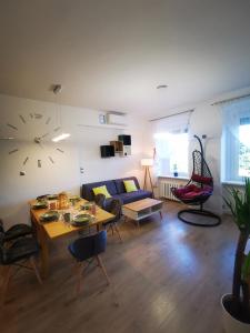 ein Wohnzimmer mit einem Tisch und einer Uhr an der Wand in der Unterkunft K&Scielna4013 in Świdnica