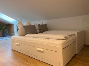 a white bed with drawers and pillows on it at *Wohnung SCHWARZWALD*Unikat in VS mit Terrasse in Villingen-Schwenningen