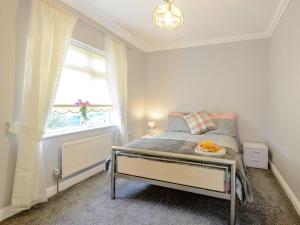 a small bedroom with a bed and a window at Fletchers Rest in Cawston