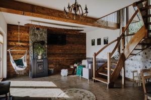 ein Wohnzimmer mit einer Holzwand und einer Treppe in der Unterkunft Leśne Zacisze in Nowy Targ
