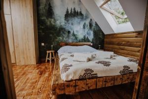 Schlafzimmer mit einem Bett mit Wandgemälde in der Unterkunft Leśne Zacisze in Nowy Targ