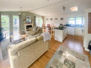 a large living room with a couch and a kitchen at Wye Lodge in Aberedw