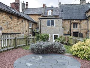 a garden with a stone circle in front of a house at Cosy Cottage in Bourton on the Hill