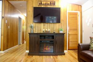 uma sala de estar com lareira e uma televisão de ecrã plano em Escape to a 3-Bedroom Cabin in Lower Catskills em Woodridge