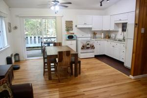 una cocina con armarios blancos y una mesa con sillas. en Escape to a 3-Bedroom Cabin in Lower Catskills, en Woodridge