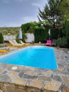 una piscina en un patio con un patio de piedra en Casa Rural Casa Pepe en Castillo de Locubín