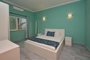 a bedroom with a bed with a blue wall at Bless Villa Apartment in Kiwengwa +37 photos