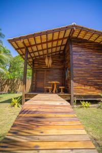 um passeio marítimo de madeira que leva a uma cabina com uma mesa em Cabana Fluir - Taipu de Fora - Península de Maraú em Barra Grande