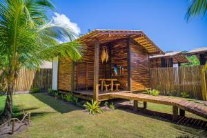 uma cabina de madeira com uma mesa e um banco em Cabana Fluir - Taipu de Fora - Península de Maraú em Barra Grande