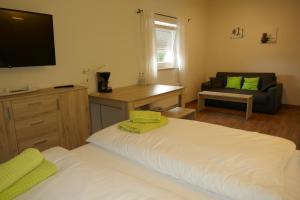 a bedroom with a large white bed and a television at Appartmentanlage/Ferienhaus Handewitt in Handewitt