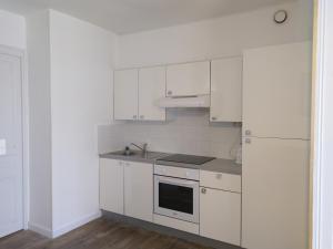 a white kitchen with white cabinets and a sink at Gabrielle 40m2, Netflix in Sainte-Savine +10 photos