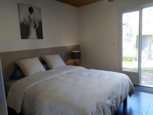 ein Schlafzimmer mit einem großen weißen Bett und einem Fenster in der Unterkunft Gabrielle 40m2 et terrasse in Sainte-Savine