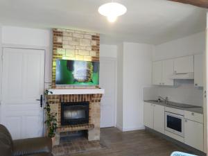 a living room with a brick fireplace with a tv above it at Gabrielle 40m2, Netflix,jardin in Sainte-Savine