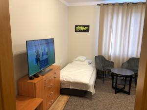Zimmer mit einem TV, einem Bett und einem Tisch in der Unterkunft Apartamenty JN Poznań Rzeczna 4 in Posen