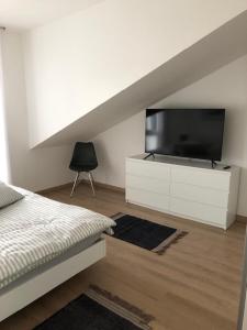 1 dormitorio con cama y vestidor con TV en Ferienwohnung Ederseeblick en Waldeck