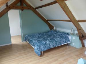 sypialnia z łóżkiem i drewnianą podłogą w obiekcie Jolie maison pour 4 à 6 personnes w mieście Ellon