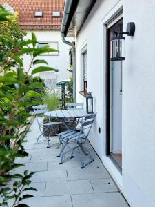 a patio with a table and chairs on the side of a building at Ferienwohnung Anna Maria Erding in Erding