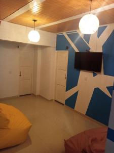 a room with a blue and white wall with a tv at The Mural Hostel Bogotá in Bogotá