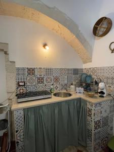 a kitchen with a sink and a counter with tiles at Casa Giulia in Martina Franca