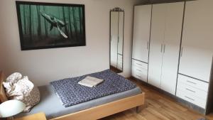 1 dormitorio con 1 cama y una pintura en la pared en HässelHof - 80qm Ferienwohnung im Zentrum von Bad Liebenwerda, en Bad Liebenwerda