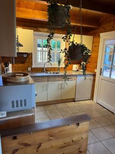 a kitchen with white cabinets and a sink at Veluwse Bungalow in Ermelo