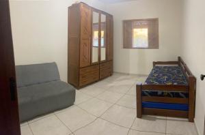 a living room with a bed and a chair at CHÁCARA COM PISCINA CLIMATIZADA e JACUZZI in Socorro