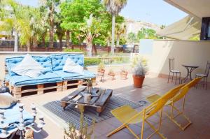 un patio con un sofá azul, sillas y una mesa en Casa Cas, en Jerez de la Frontera