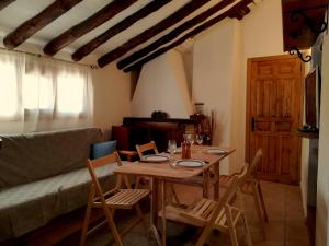 a table and chairs in a living room with a couch at Los Cantaricos in Letur