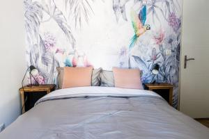 a bedroom with a bed with a bird wallpaper at Chambre tropicale privée au coeur d'un village calme et proche du vignoble in Vinzelles