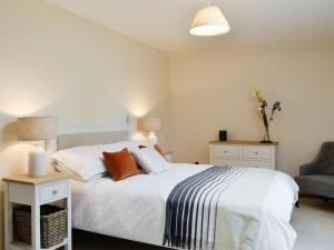 a bedroom with a large white bed and a chair at The Stables - Uk11108 in Montrose