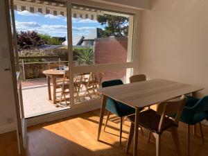 comedor con mesa y sillas y balcón en Trouville, appartement rénové avec grande terrasse au calme en Trouville-sur-Mer