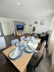 a dining table and chairs in a living room at Gemütliche Neubauwohnung 70qm in Eichenzell